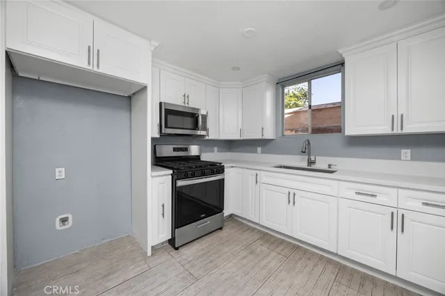a kitchen with sink a microwave and cabinets