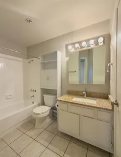 a bathroom with a granite countertop sink toilet a large mirror a bathtub and shower