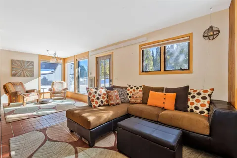 a living room with furniture a flat screen tv and a window