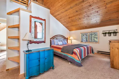 a bedroom with a bed and a lamp on dresser