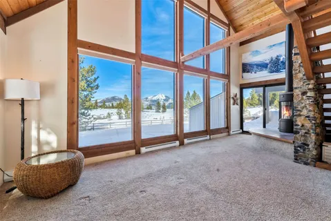 a view of an empty room with a floor to ceiling window and a tree