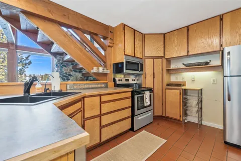 a view of kitchen with stainless steel appliances and cabinets