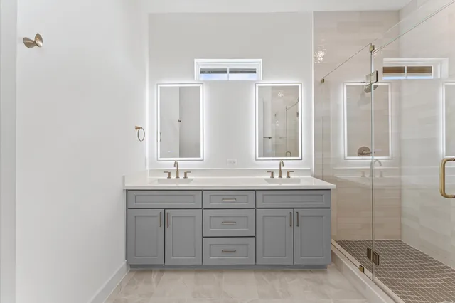 a bathroom with double sink and a mirror