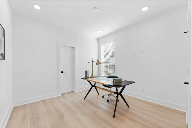 a view of a room with chairs and wooden floor