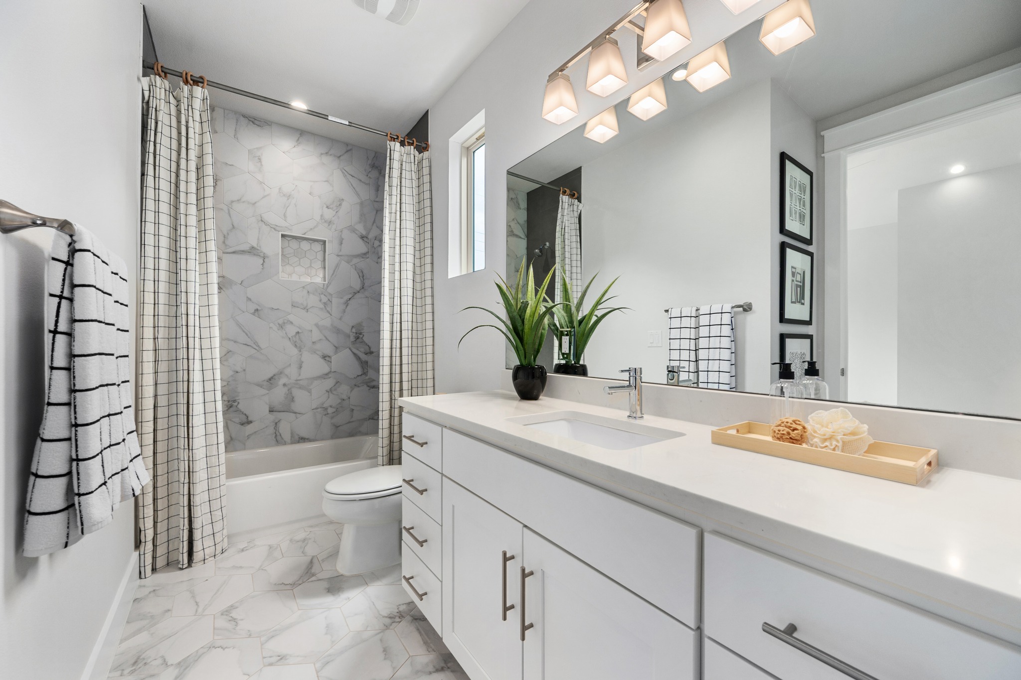 1409 Alegria Road, Unit A Austin, TX 78757 - Photo 19 of 24 Clean lines and bright finishes elevate this functional primary bath, complete with a modern vanity and tiled shower.