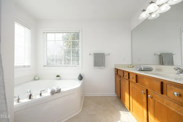 a bathroom with a tub a sink and a window