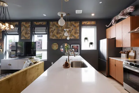 a kitchen with stainless steel appliances kitchen island granite countertop a refrigerator a stove and a sink with large countertops