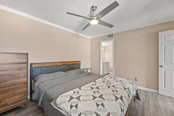 a bedroom with a large bed and a chandelier
