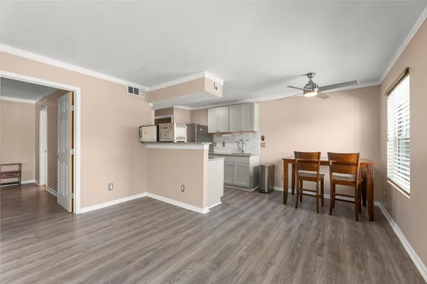 a kitchen with a table chairs refrigerator and cabinets