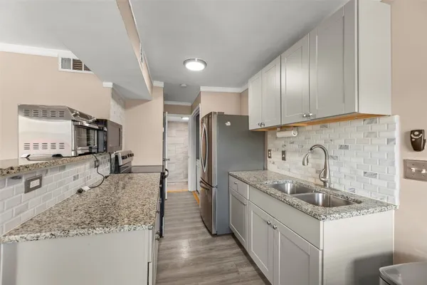 a kitchen with stainless steel appliances granite countertop a sink stove and refrigerator