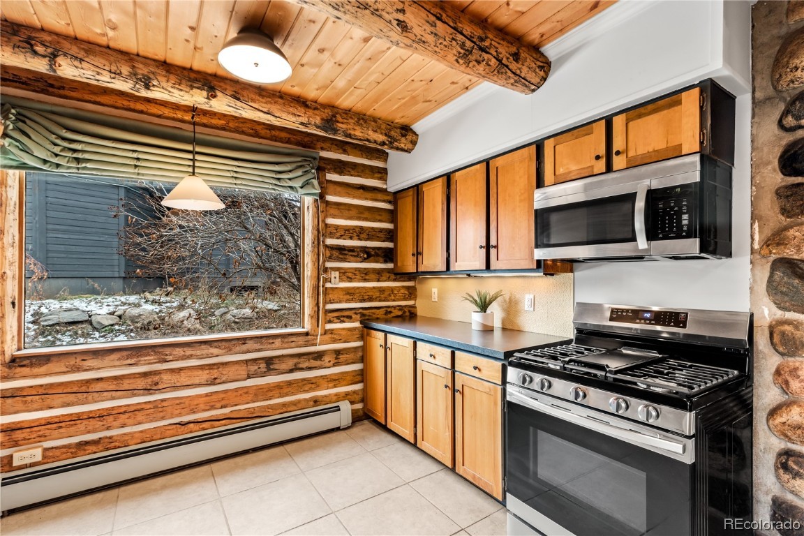 1527 Natches Road Steamboat Springs, CO 80487 - Photo 11 of 50 a kitchen with wooden cabinets and a stove top oven
