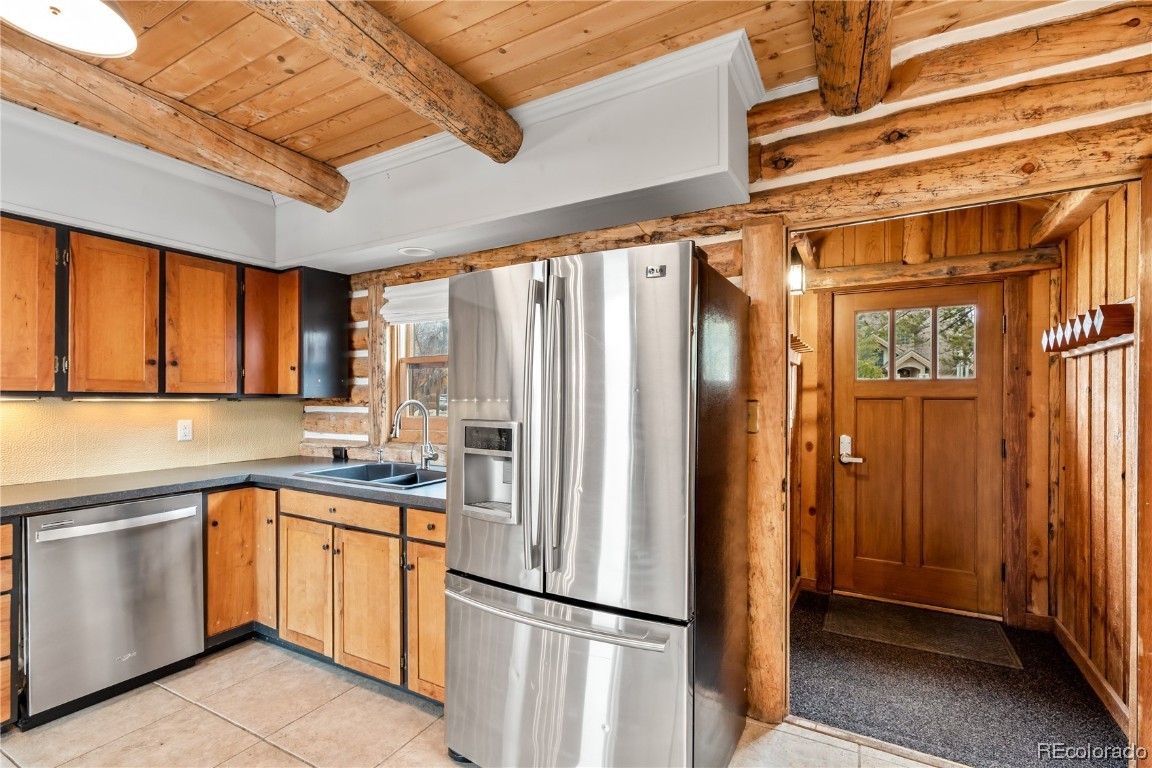 1527 Natches Road Steamboat Springs, CO 80487 - Photo 12 of 50 a kitchen with a refrigerator a sink and cabinets