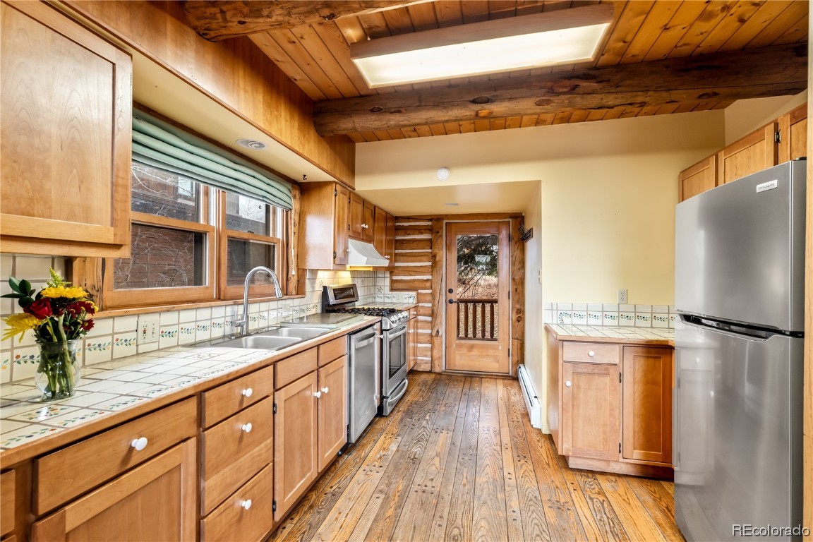 1527 Natches Road Steamboat Springs, CO 80487 - Photo 34 of 50 a kitchen with stainless steel appliances granite countertop a refrigerator a stove and a wooden floors