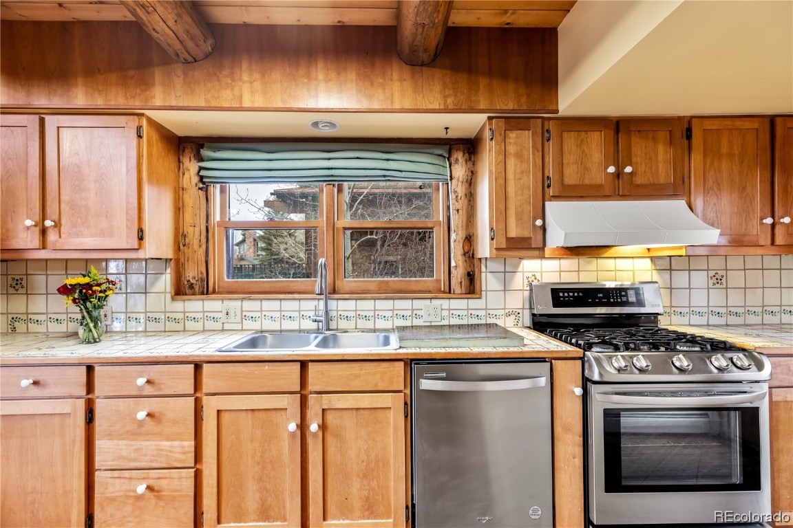 1527 Natches Road Steamboat Springs, CO 80487 - Photo 35 of 50 a kitchen with stainless steel appliances granite countertop a stove a sink and a microwave