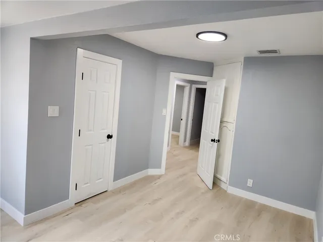 a view of a hallway with wooden floor and closet