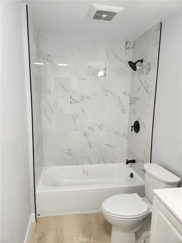 a white toilet and tub sitting next to a bathroom sink