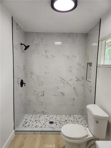 a bathroom with a toilet and a shower