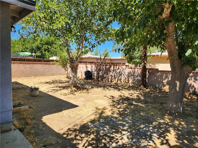 a view of a yard with wooden fence