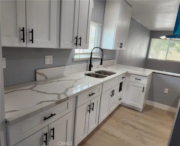 a kitchen with granite countertop white cabinets and white appliances