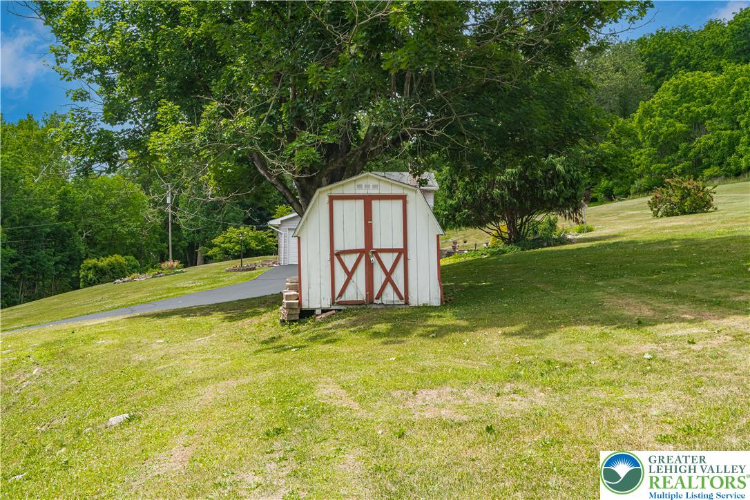 50 Kohls Road Northampton, PA 18067 - Photo 38 of 54 A charming backyard shed with a rustic red and white facade provides practical outdoor storage.