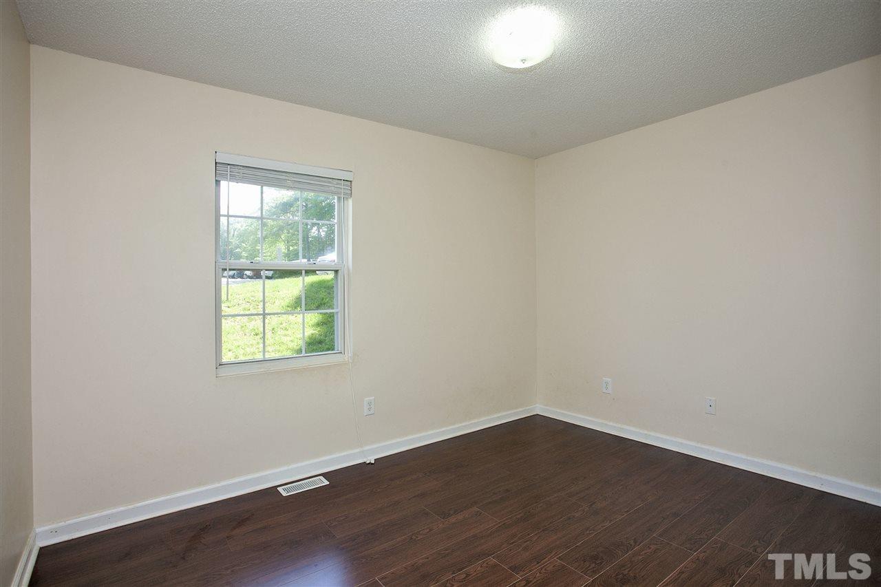 1145 Marlborough Road Raleigh, NC 27610 - Photo 13 of 17 an empty room with wooden floor and windows
