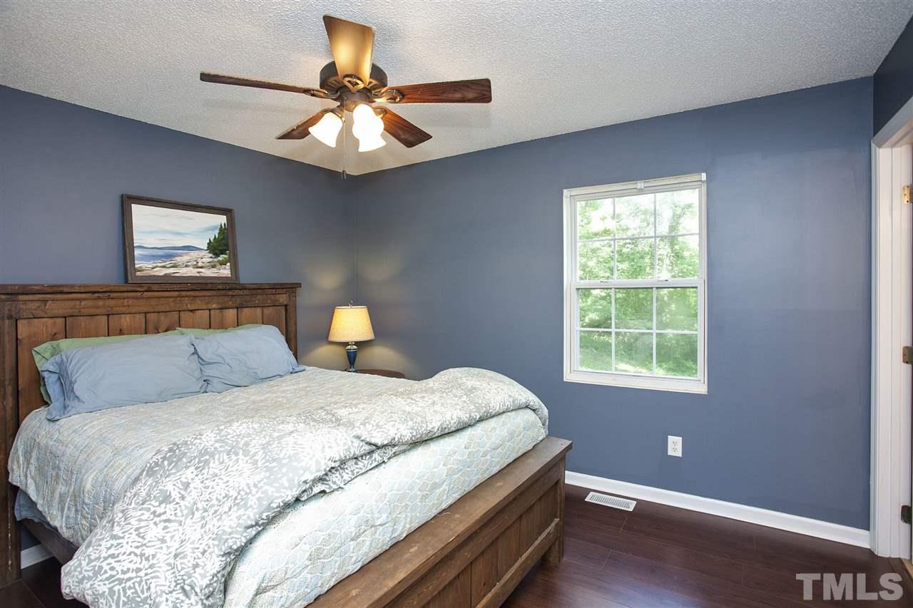 1145 Marlborough Road Raleigh, NC 27610 - Photo 9 of 17 a bedroom with a bed and a chandelier