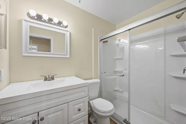 a bathroom with a sink toilet a mirror and shower