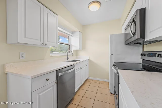 a kitchen that has a sink and a stove top oven
