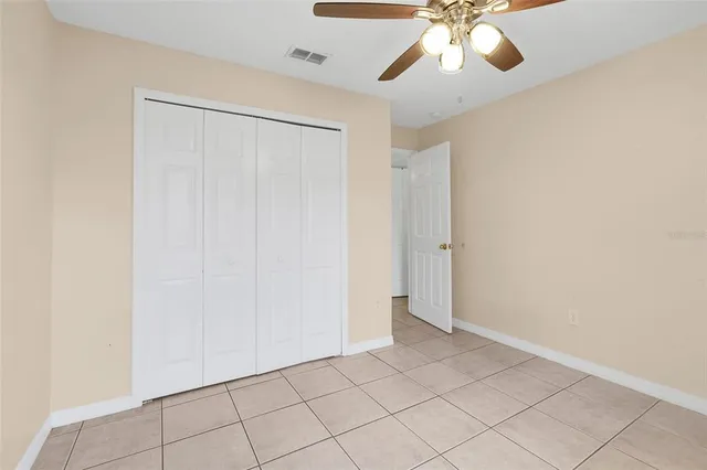 a view of an empty room and chandelier fan