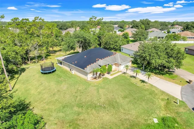 a view of a swimming pool with lawn chairs and potted plants