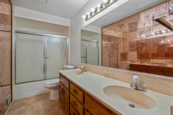 a bathroom with a double vanity sink toilet and mirror