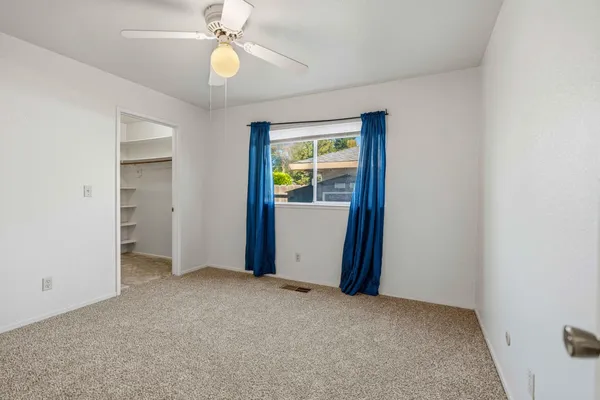 an empty room with windows and closet