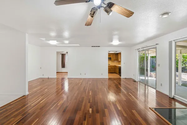 a view of empty room with wooden floor
