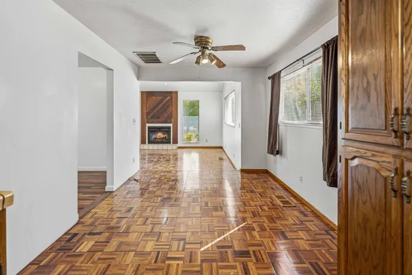 a view of a hallway with wooden floor and a chandelier