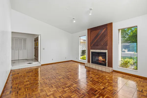 a view of an empty room with a fireplace and a window