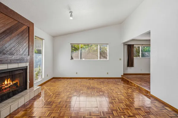 a view of an empty room with window and fire place