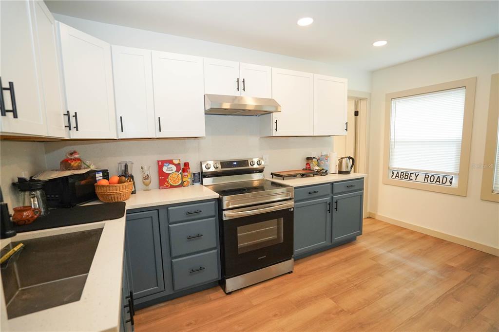 535 14th Avenue South, Unit W St. Petersburg, FL 33701 - Photo 5 of 15 a kitchen with granite countertop wooden cabinets and white appliances