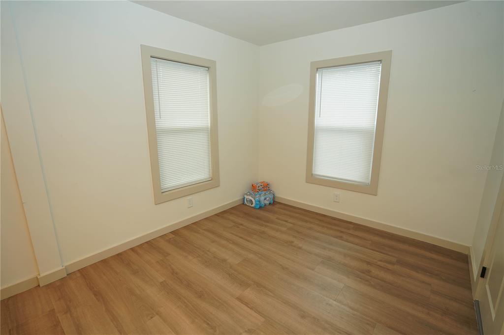 535 14th Avenue South, Unit W St. Petersburg, FL 33701 - Photo 8 of 15 an empty room with wooden floor and windows