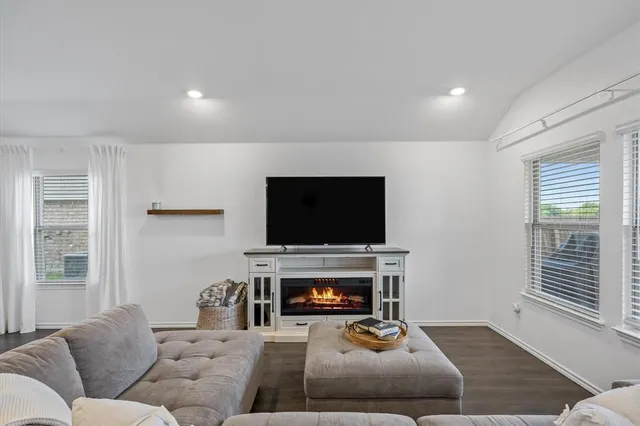 a living room with furniture a flat screen tv and a fireplace