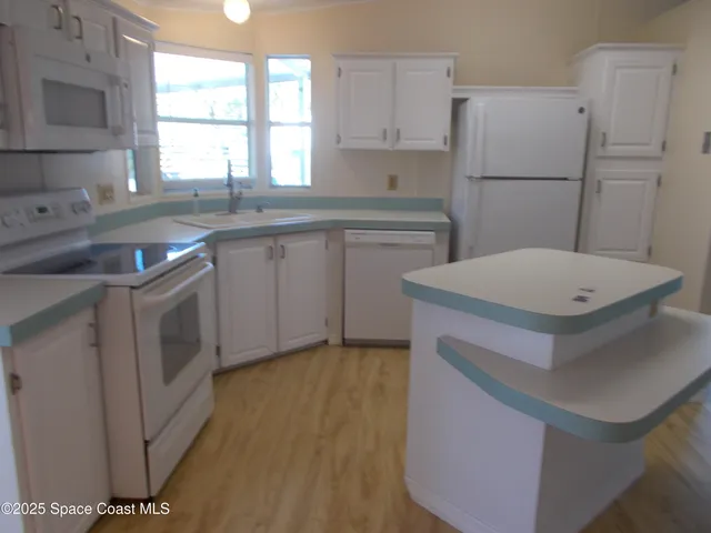 a kitchen with a sink appliances a window and a counter top space