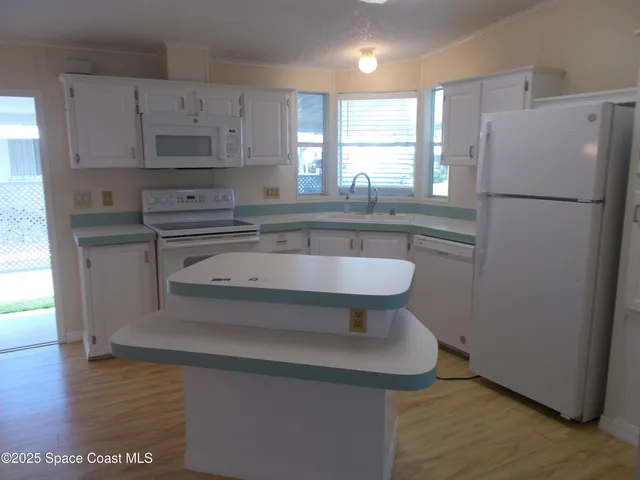 a kitchen with stainless steel appliances a refrigerator a sink a stove a microwave and cabinets