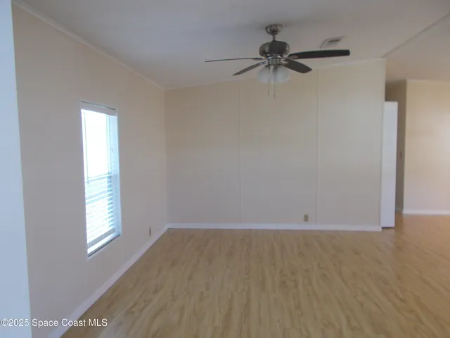 a view of a room with a window and a ceiling fan