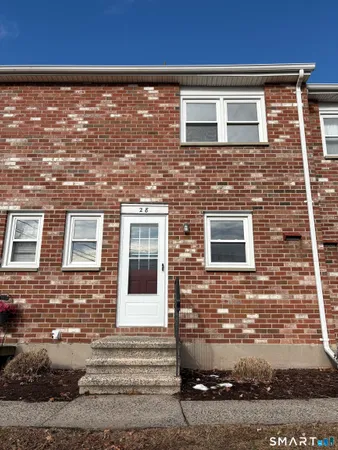 front view of a brick house with a small yard