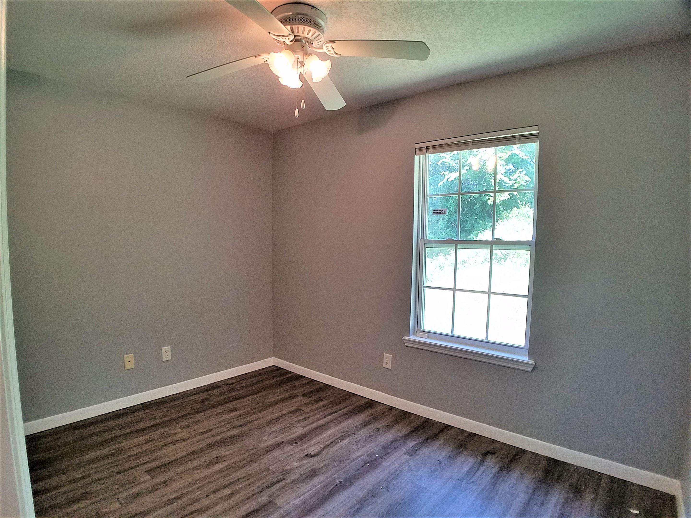 870 13th Street St. Augustine, FL 32084 - Photo 14 of 28 an empty room with wooden floor chandelier fan and windows