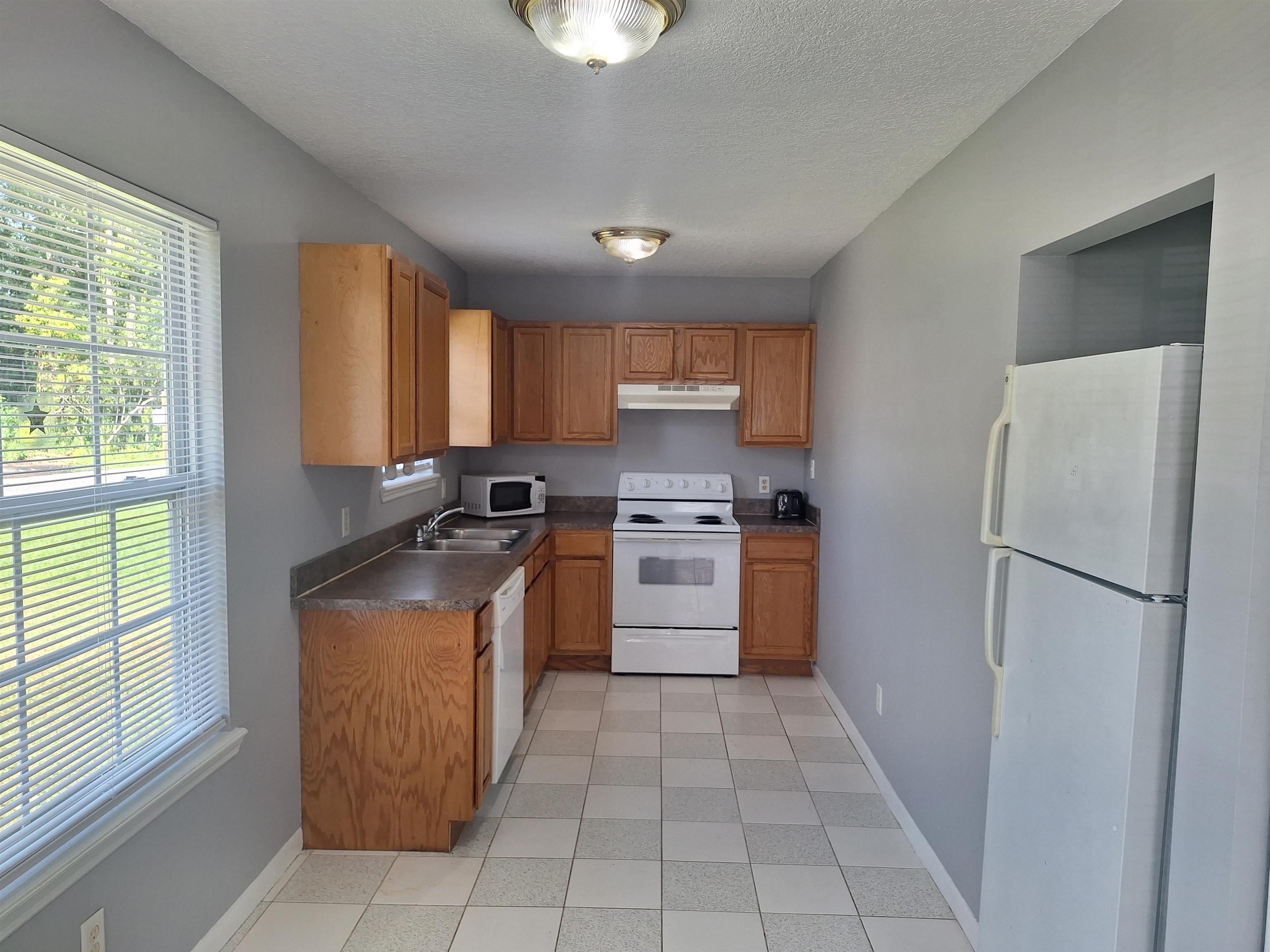 870 13th Street St. Augustine, FL 32084 - Photo 8 of 28 a kitchen with a refrigerator a stove top oven and cabinets