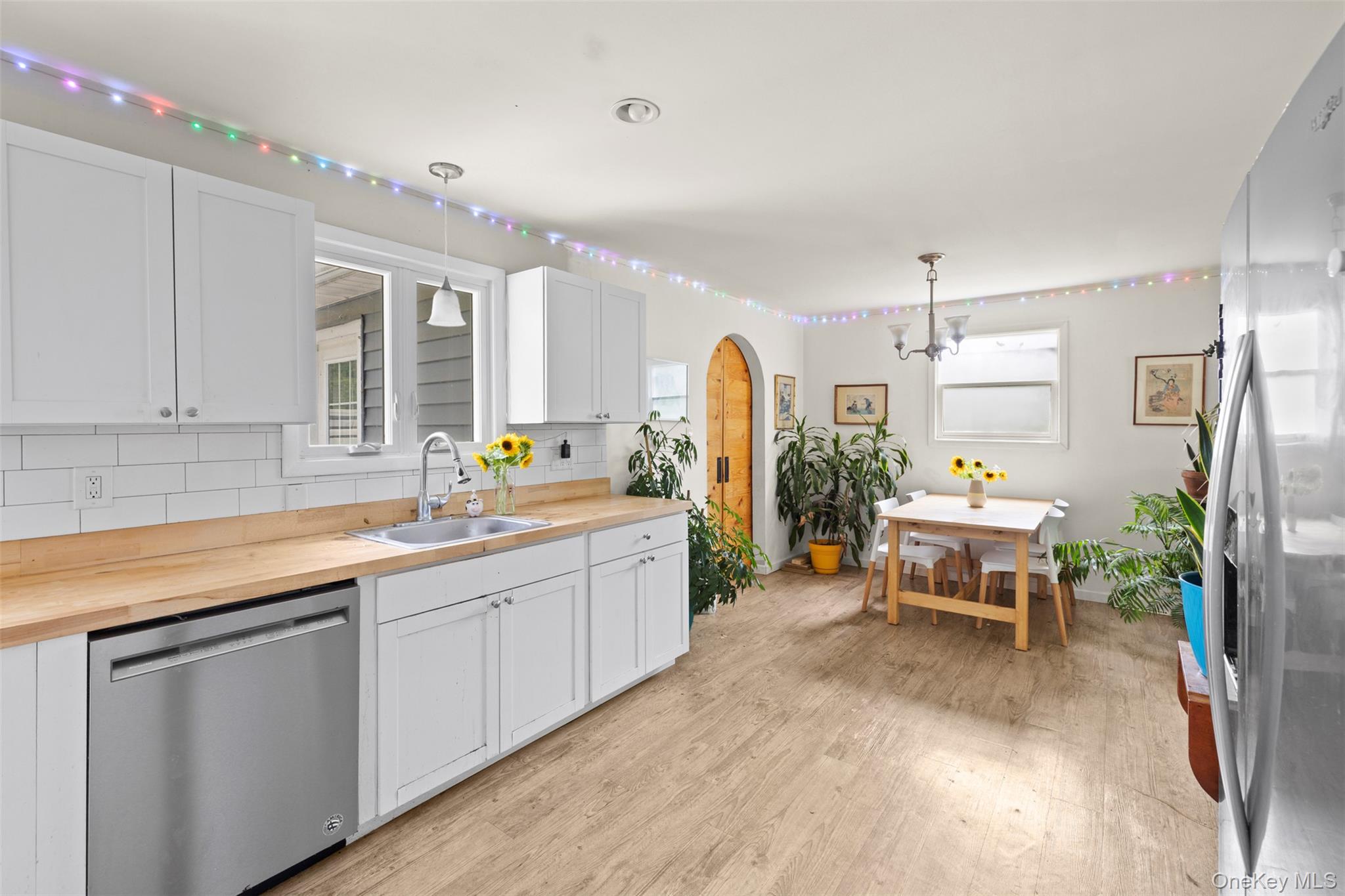 44 Woods Road Tivoli, NY 12583 - Photo 14 of 25 Kitchen featuring appliances with stainless steel finishes, butcher block counters, light wood-style floors, backsplash, and a chandelier