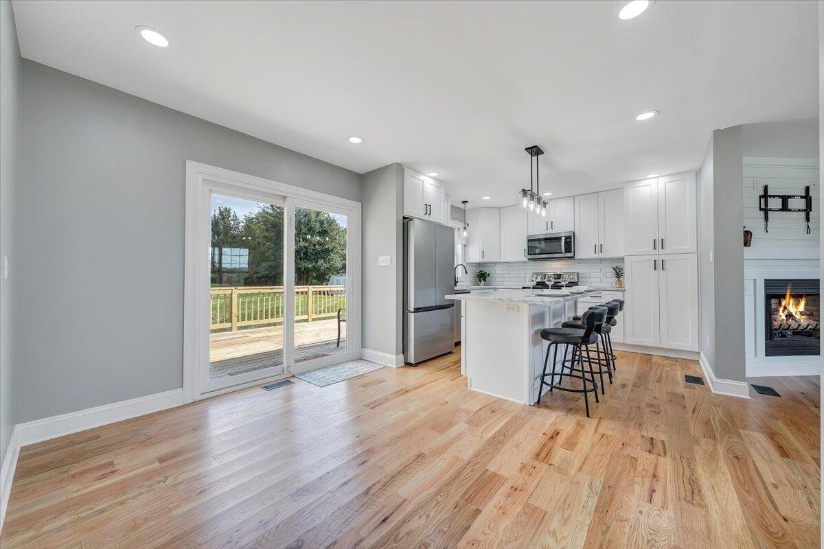 155 Mallard Cove Road Moneta, VA 24121 - Photo 11 of 51 a open kitchen with stainless steel appliances kitchen island a large counter top and a wooden floors
