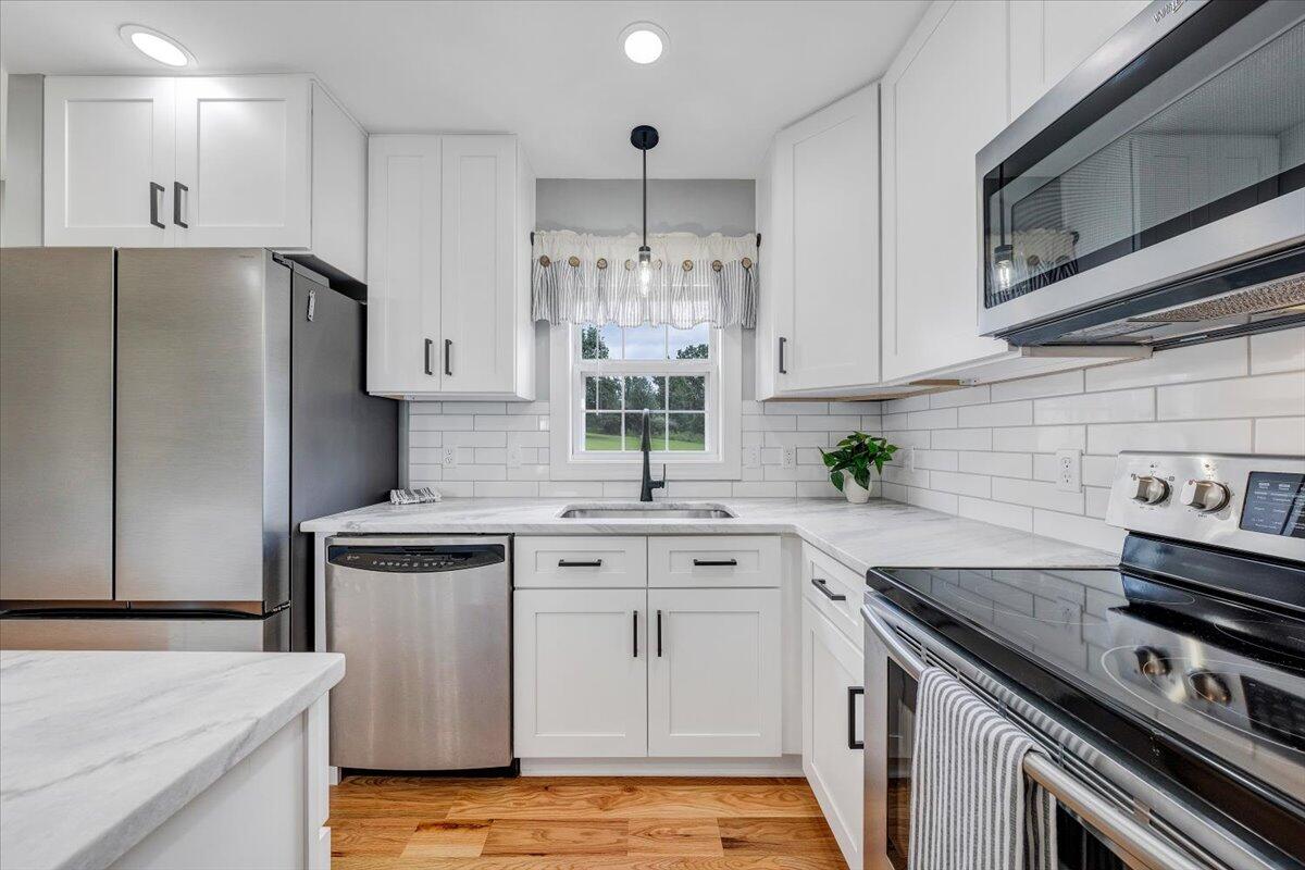 155 Mallard Cove Road Moneta, VA 24121 - Photo 2 of 51 a kitchen with white cabinets stainless steel appliances and a counter space