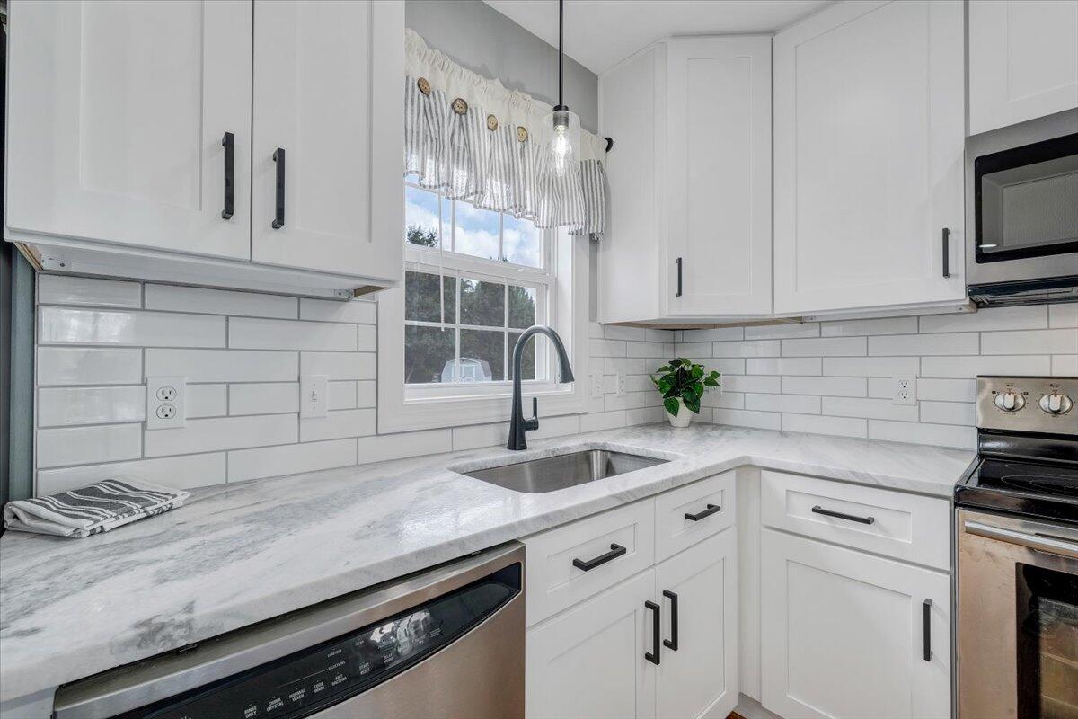 155 Mallard Cove Road Moneta, VA 24121 - Photo 8 of 51 a kitchen with granite countertop a sink a stove and cabinets