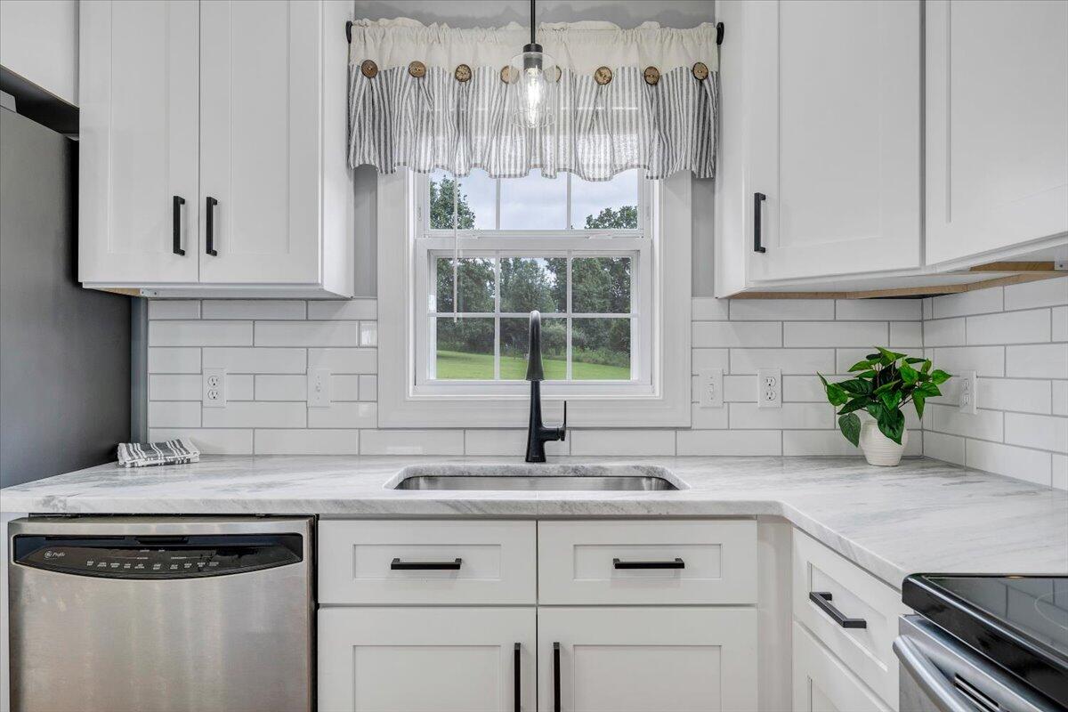 155 Mallard Cove Road Moneta, VA 24121 - Photo 9 of 51 a kitchen with stainless steel appliances granite countertop a sink a stove and white cabinets